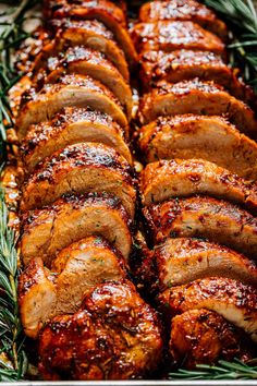 sliced pork roast in a pan with rosemary sprigs