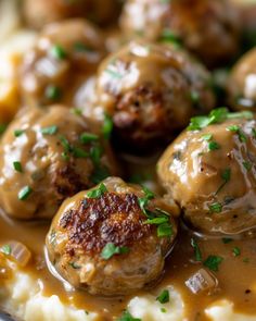 meatballs covered in gravy on top of mashed potatoes