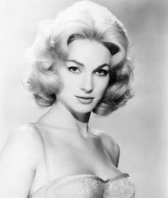 an old black and white photo of a woman in a strapless dress with her hair up