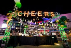 the entrance to an event with lights and decorations on it's arch that says cheers