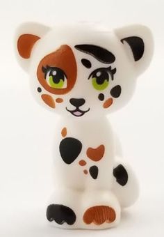 a white and brown toy with black spots on it's face, sitting in front of a white background