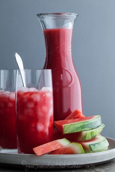 watermelon juice and cucumber slices on a plate next to a pitcher