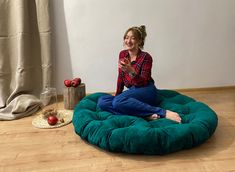 a woman sitting on a bean bag chair in the middle of a room with apples