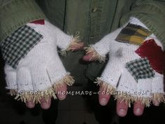 two hands wearing white knitted gloves with red, green and yellow plaid designs