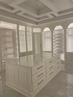 a large kitchen with white cabinets and marble flooring on the walls, along with built - in shelving