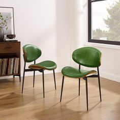 two green chairs sitting in front of a window