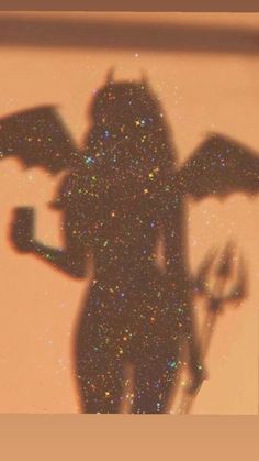 the shadow of a person holding an umbrella in front of a window with glitters on it