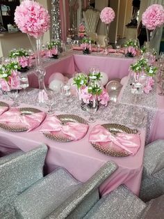 the table is set with pink and silver decorations