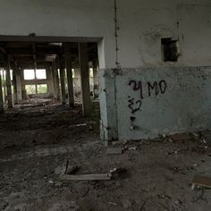 an abandoned building with graffiti on the wall and flooring in it's center