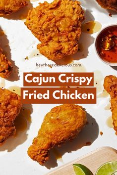 fried chicken is served on a plate with sauce and limes next to the words cajun crispy fried chicken