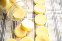 several pieces of butter sitting on top of a table cloth next to a jar with some cut up slices