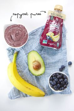 an avocado, banana, blueberries and peanut butter on a towel