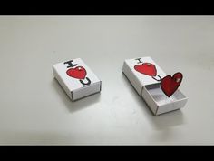 two small boxes with hearts on them sitting on a table