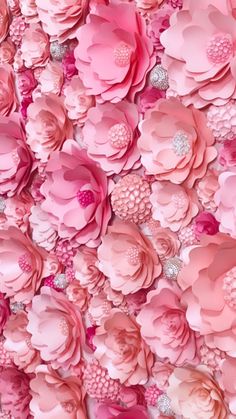 pink paper flowers are arranged on the wall