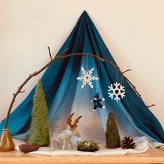 a wooden shelf topped with fake trees and snowflakes