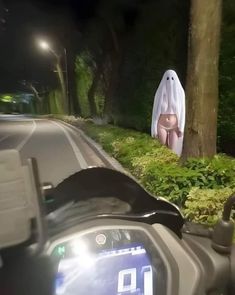 a motorcycle driving down a road with a ghost on it