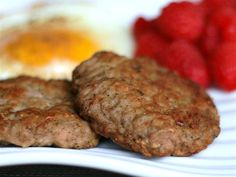 two hamburger patties on a plate with strawberries