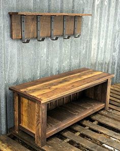 a wooden bench sitting on top of a pallet floor next to a metal wall