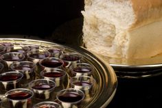 a loaf of bread sitting on top of a metal pan filled with glasses of wine