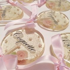 wedding favors with pink ribbons and name tags on the top one is for each bride