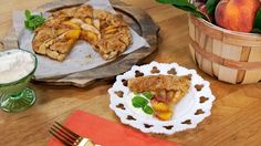 a table topped with pies and fruit on top of wooden cutting board next to utensils