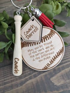 a baseball keychain with a bat on it and some leaves in the background