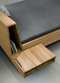 a bed with drawers underneath it and a black blanket on the bottom shelf next to it