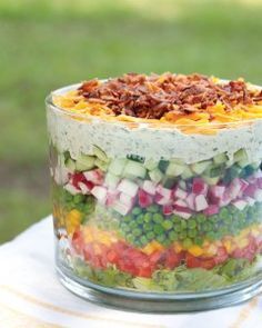 a layered salad in a glass dish on a table