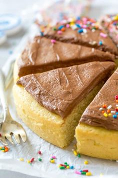 a piece of cake with chocolate frosting and sprinkles next to a fork