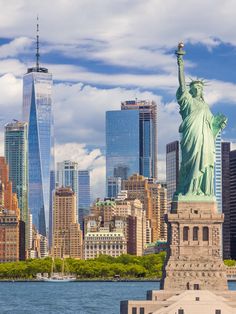 the statue of liberty stands in front of new york city's skyline and skyscrapers