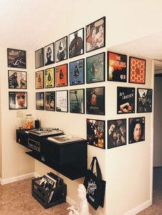 a wall with many pictures on it and a record player in the corner next to them