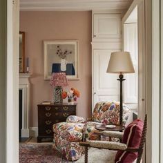 a living room filled with furniture and a fire place under a painting on the wall