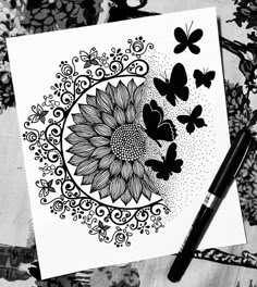 a black and white drawing of a sunflower with butterflies on it, next to a marker pen