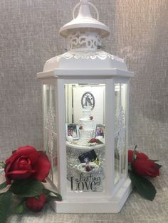 a white lantern with roses on the side and a card in it that says i love you