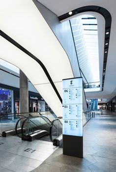 an escalator in the middle of a building with stairs and signs on it