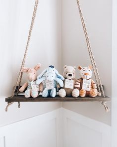 there are many stuffed animals hanging on the shelf in this room, and one is holding a baby's name