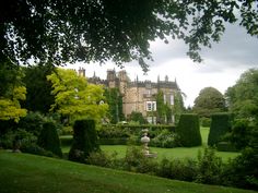 a large building with lots of trees and bushes around it