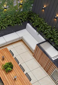 an overhead view of a patio with table, bench and potted plants on it