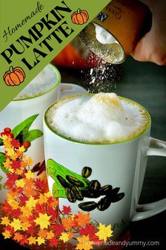 pumpkin latte is being poured into two mugs with autumn leaves on the side