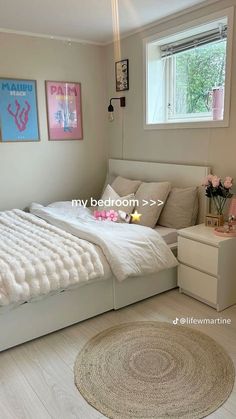 a bedroom with a bed, dresser and rug on the floor in front of a window