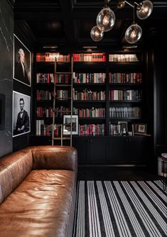 a leather couch sitting in front of a book shelf filled with books