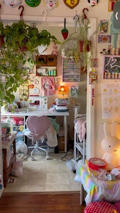 a room filled with lots of clutter and plants hanging from the ceiling above it