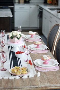 a table set with pink and white dishes