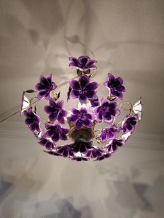 a chandelier with purple flowers hanging from the ceiling