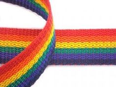 a rainbow colored knitted ribbon on white background