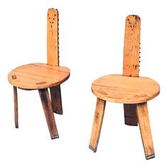 two wooden chairs sitting side by side with holes in the back and one chair made out of wood