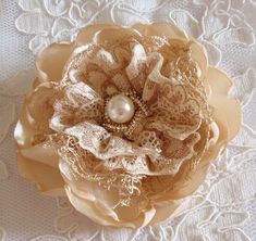 a close up of a flower on a lace doily with pearls and beads in the center