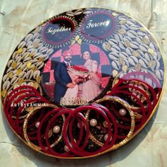 an artisticly decorated plate with red and gold hair clips on it's sides