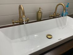 a bathroom sink with two faucets and soap dispenser