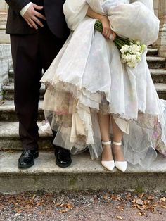 a man and woman in wedding attire standing on steps